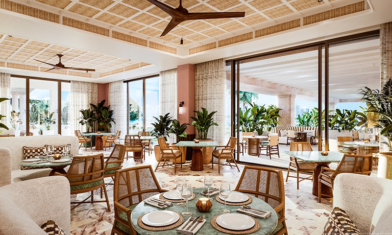 Elegant lounge at 6 Fisher Island Residences with modern furnishings, seamless indoor-outdoor flow, lush greenery, and stunning waterfront views